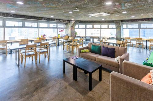 釜山釜山米花旅馆的带沙发、桌子和椅子的房间