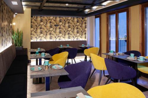莱昂Palacete Colonial的餐厅设有紫色和黄色的椅子和桌子