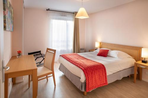 新城勒鲁瓦多米蒂斯莱沙布勒多洛公寓式酒店的酒店客房配有一张床铺、一张桌子和一张书桌。