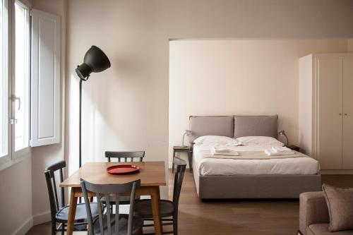 佛罗伦萨Pietrapiana Boutique Apartments的卧室配有一张床和一张桌子及椅子