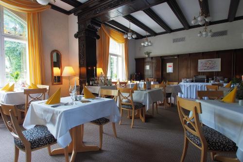 Derenburg德朗堡城堡别墅酒店的一间设有白色桌椅的用餐室