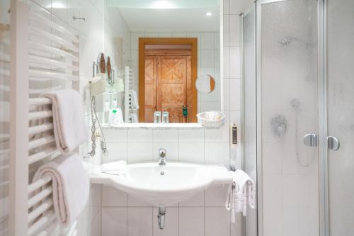福森阿克提夫施威格尔酒店的白色的浴室设有水槽和淋浴。