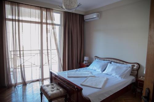 巴统Cozy Guest House in Old Batumi的一间卧室设有一张床和一个大窗户