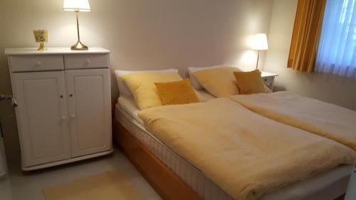 青斯特Achtern - Diek - am Strand的一间卧室配有一张大床,上面有两盏灯
