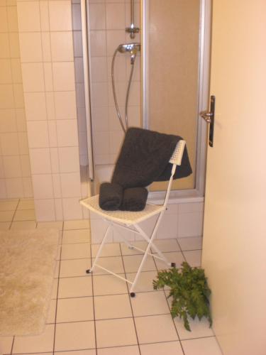 青斯特Achtern - Diek - am Strand的浴室里配有毛巾和椅子上的淋浴