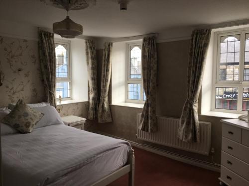 查尔斯敦Riverside Guesthouse的一间卧室设有一张床和三个窗户。