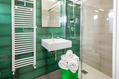 阿尔本加Umémà B&B的浴室设有绿色瓷砖墙壁和水槽