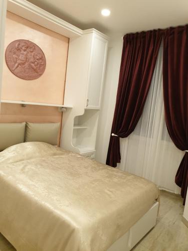 奇维塔韦基亚Museum Guest House的一间卧室配有床和红色窗帘