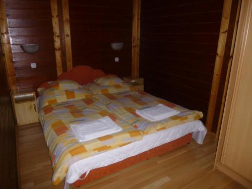 MátraszeleRigófészek Vendégház的客房内的一张带毛巾的床