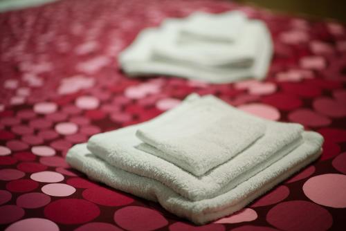 罗马德利兹伊法布里奇奥旅馆的红色和白色桌子上摆放着三条白色毛巾