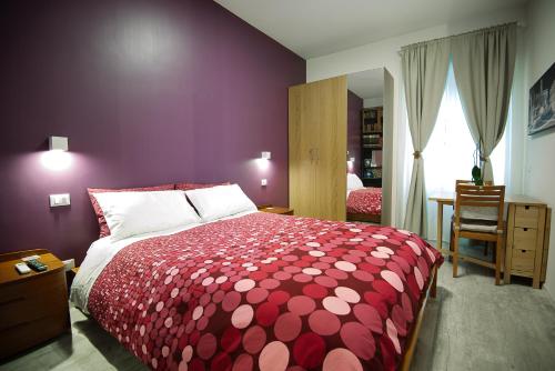 罗马德利兹伊法布里奇奥旅馆的卧室设有红色和白色的床和窗户。