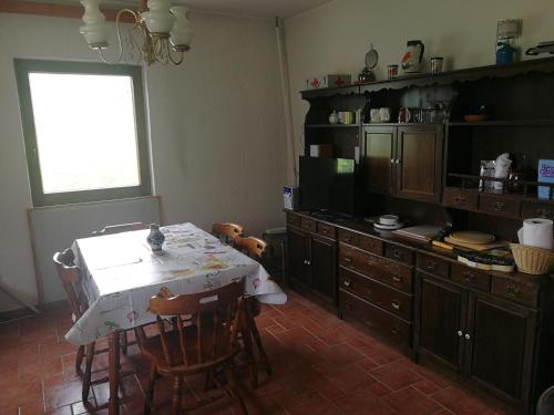 希洛Ecohouse Oliveglia的厨房配有桌椅和电视。