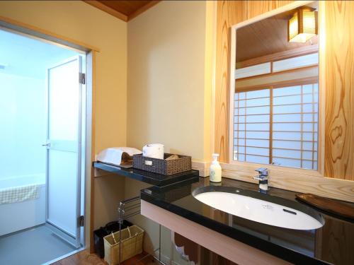 山之内町嘉美浴场旅馆的一间带水槽和镜子的浴室