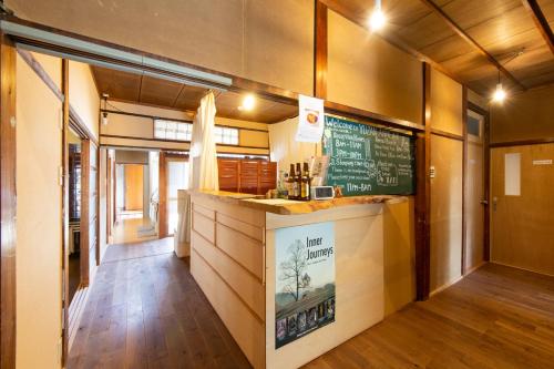 奈良Yuzan Guesthouse的墙上有柜台和黑板的餐厅