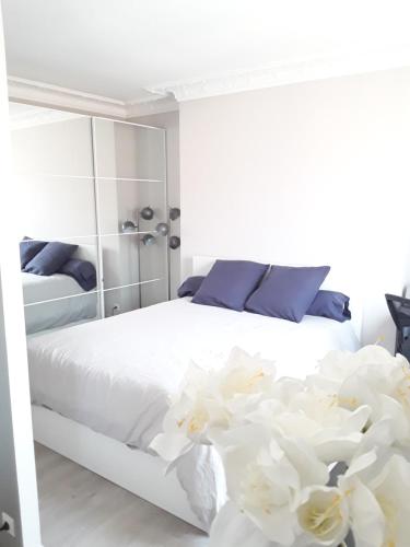 巴黎Apartment with Car Park - Bastille Neighborhood的一间卧室配有白色床单和鲜花。