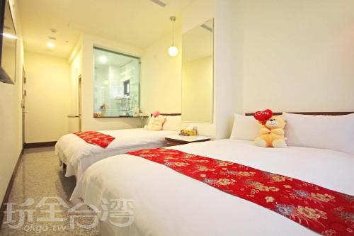 鱼池乡Sun Moon Lake Crown Yu Hotel的一间卧室配有两张红色和白色床单