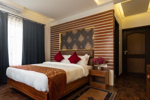 迦瓦拉科尔Fresco Retreat的一间卧室配有一张大床和木制床头板