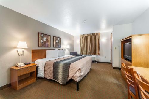 奥法伦Welcome Suites-O'Fallon的酒店客房,配有床和电视