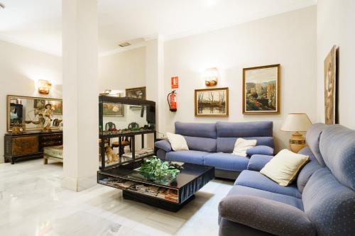莫特里尔Hotel Costa Andaluza的客厅配有蓝色的沙发和桌子