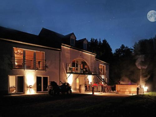 威布林Luxurious Villa in Houffalize with Sauna的夜间停在房子前面的两辆摩托车房子