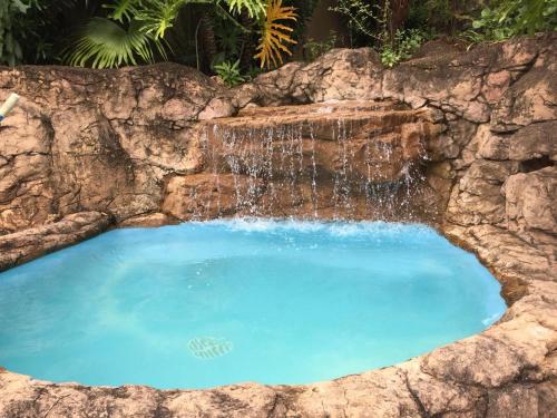 马盖特Tranquility的一座石头墙内的大型游泳池,瀑布