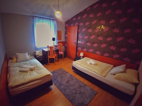 希隆斯克地区佩卡雷Hotel Komfort Inn - Dwór Hubertus的一间卧室配有两张床、一张桌子和一把椅子