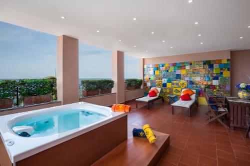 陶尔米纳卡帕莱纳酒店的一间大房间,在房子里设有按摩浴缸