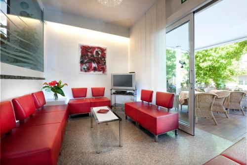 里米尼费利克斯酒店 的客厅配有红色沙发和电视