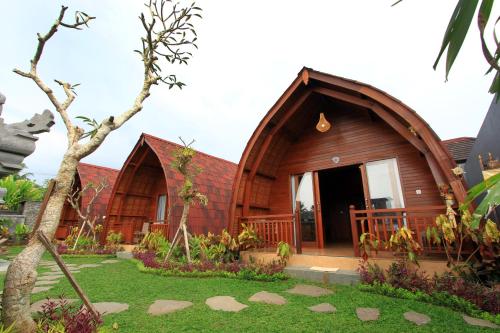 乌布Pondok Naya - CHSE Certified的一座小木房子,前面设有一个花园