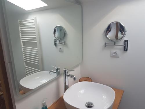 GenayL'Angélus的浴室设有白色水槽和镜子