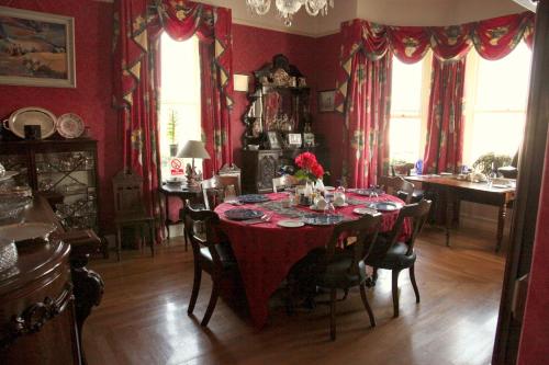 韦斯特波特洛斯考茵旅馆的一间带红色桌布的餐桌的用餐室