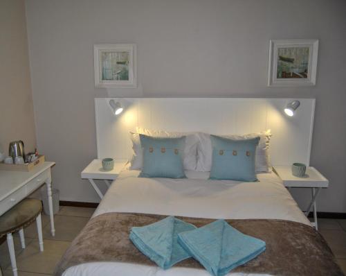彼得马里茨堡Hamilton Urban Farm Guest House的卧室配有带蓝色枕头的大型白色床