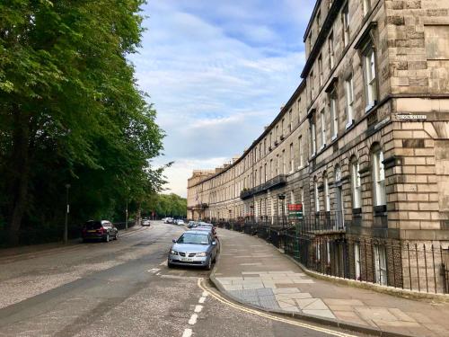 爱丁堡Escape to Edinburgh @ Abercromby Place的停在大楼旁的街道上的汽车