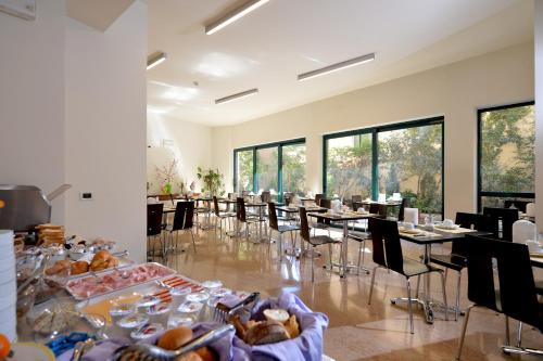 维罗纳西耶那酒店的用餐室设有桌椅和窗户。