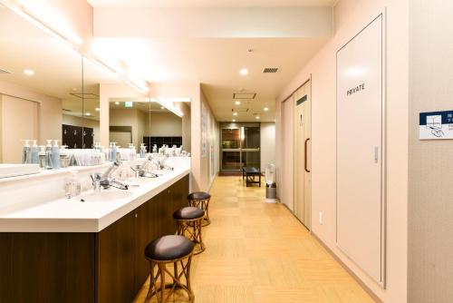 高山飞驒高山华盛顿广场酒店的浴室设有一排盥洗盆和镜子
