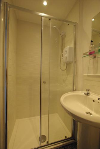 桑当沙丘旅馆的水槽旁的玻璃门淋浴