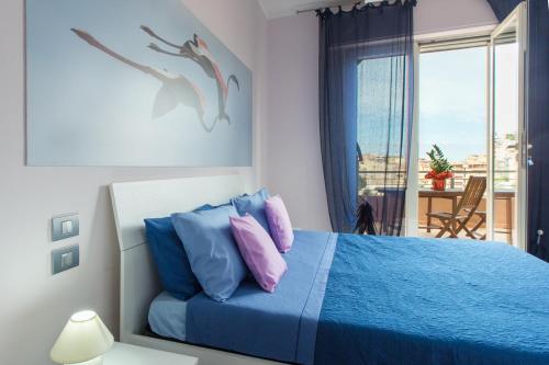 卡利亚里A View on Cagliari的一间卧室配有蓝色的床和蓝色和粉红色的枕头