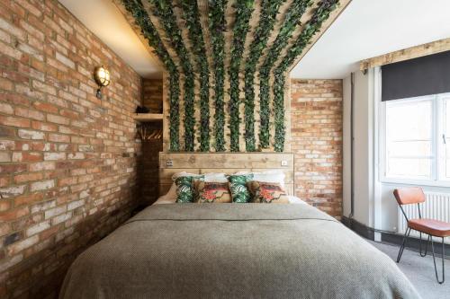 布莱顿霍夫One Broad Street的一间卧室设有砖墙和一张床