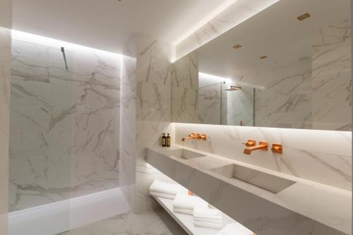 蓬塔德尔加达Azor Central Lodge的一间设有白色大理石墙壁和淋浴的浴室