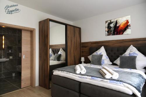 Uhingen齐柏林公寓的一间卧室配有一张大床和镜子