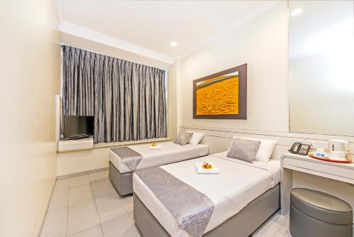 新加坡Hotel 81 Elegance的酒店客房设有两张床和电视。