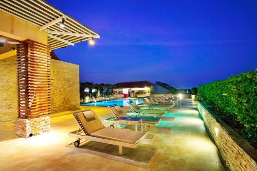 芭堤雅市中心Intimate Hotel Pattaya - SHA Extra Plus的一个带躺椅的庭院和夜间游泳池
