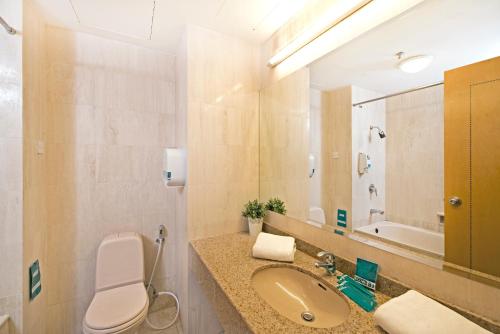 新加坡Hotel 81 Tristar的一间带卫生间、水槽和镜子的浴室