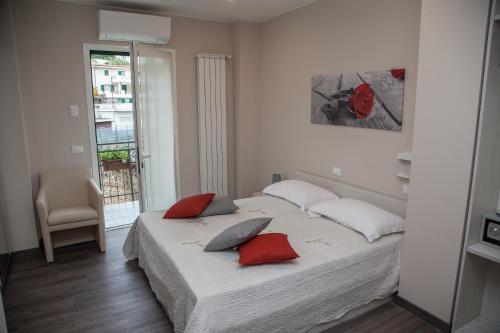 圣雷莫Casa delle Ginestre Bike的一间卧室配有一张带红色枕头的床