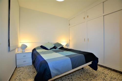 卡拉费尔Villaservice - Leonor的一间卧室配有蓝色和白色床单