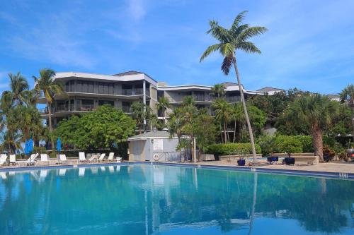 基韦斯特Coconut Palms的一座棕榈树建筑前的大型游泳池