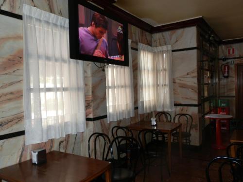 孔苏埃格拉Hostal San Poul的一间设有桌子的用餐室和墙上的电视
