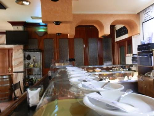 孔苏埃格拉Hostal San Poul的餐厅设有长柜台,供应白色菜肴