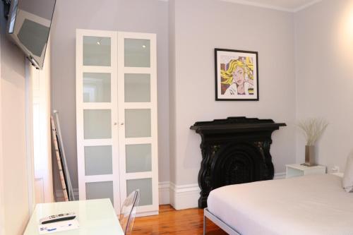 波士顿Downtown Beacon Hill, Convenient, Comfy Studio #10的白色的客房设有一张床和一个壁炉
