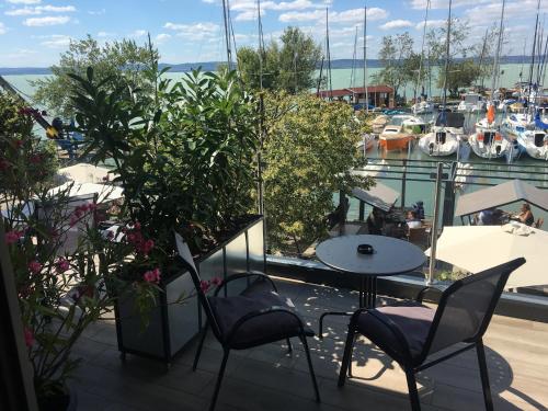 希欧福克Calypso Lakeside Rooms & Lux Apartments的阳台配有桌椅和码头